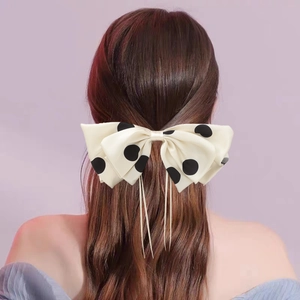 Elegant polka dot bow hair clip with long ribbons worn on the back of the head