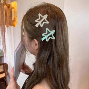 Star-shaped jelly hair clips in cream and light green on brown hair for a sweet look