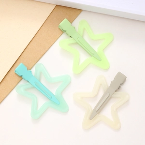 Detail of star-shaped hair clips in jelly mint green and cream white colors