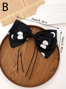 Polka dot bow hair clip with long ribbons on a vintage wooden tray background