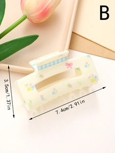 Detailed view of cream hair claw clip with floral patterns and pink bow showing 7.4cm size