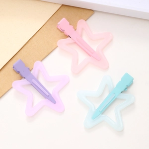 Close-up of matte star hair clips in pastel pink, purple, and cyan blue macaron shades