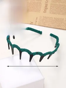Detailed view of dark green wavy resin headband with fabric wrap and inner grip teeth