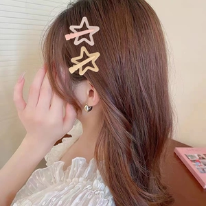 Close-up of pink jelly star-shaped hair clip worn on side hair with heart earring