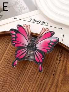 Vue détaillée d'une pince à cheveux papillon dégradé rose de 7,5 cm sur plateau en bois