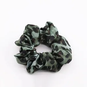 Detailed view of large green leopard print scrunchie made of silky satin fabric