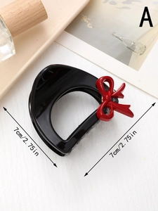 Détail de la pince à cheveux noire de 7cm avec un nœud rouge et mesures indiquées