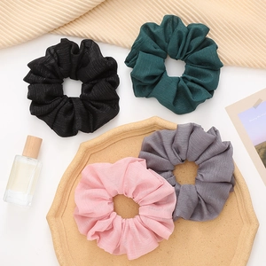 French style pleated scrunchies set in neutral colors on a minimalist decorative tray