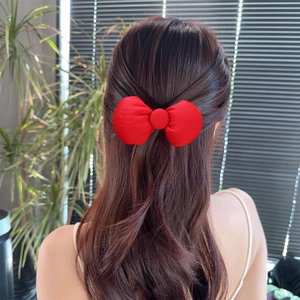 Sweet large red bow hair clip for women styled on long wavy hair back view