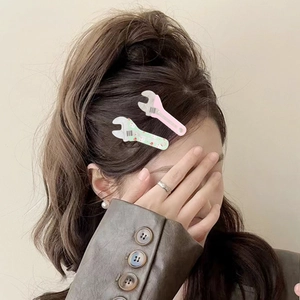 Cute acrylic macaron wrench hair clips in pink and green colors on a female model