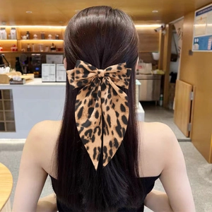 Barrette à cheveux avec nœud léopard multicouche et rubans longs sur cheveux sombres