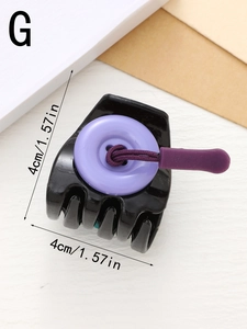 Detail view of a black 4cm hair claw clip with a purple button and elastic cord design