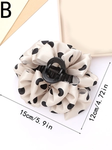 Dettaglio di un grande fermaglio per capelli beige a pois con misura di 15 cm