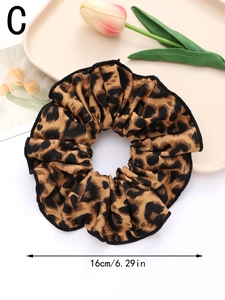Detail showing the 16cm diameter of the leopard print scrunchie on a decorative tray