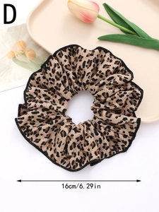Detail showing a 16cm leopard print scrunchie with elegant black stitched edges