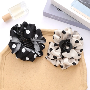 Pinze per capelli retrò a pois in tessuto di seta nero e beige su un vassoio elegante