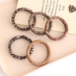 Detail of five durable high-elastic leopard and zebra print hair ties in a tray