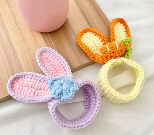 Dettaglio di elastici per capelli fatti all'uncinetto con orecchie di coniglio e fiori