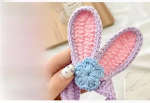 Dettaglio di elastico per capelli a uncinetto con orecchie di coniglio e fiore blu
