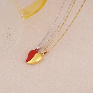 Detail of magnetic interlocking heart pendants in red and gold on fine link chains