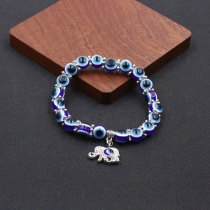 Dettaglio del braccialetto Evil Eye con ciondolo elefante in argento su legno