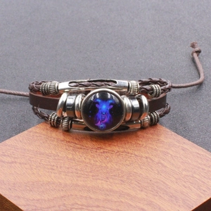 Detailweergave van de geweven leren Steenbok-armband met lichtgevende glazen koepel en koord