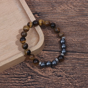 Detailed macro shot of 8mm tiger eye and hematite beads on a rustic wooden tray