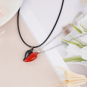 Detail of red and black magnetic heart pendants with contrasting chains for couples