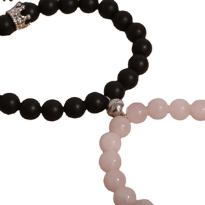 Magnetic couple bracelets with black matte and pink beads featuring crown pendants