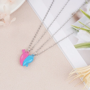 Close-up of heart-shaped magnetic couple necklaces in pink and blue with arrow detail