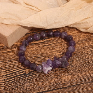 Bracciale di perline in ametista naturale con pietre viola grezze su sfondo in legno