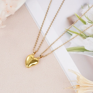 Close-up of magnetic golden heart pendant necklaces on a floral background