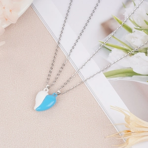 Detail showing magnetic heart couple necklaces in blue and white on a romantic floral background