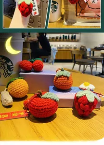 Détail de breloques en crochet faites main avec fraises et oranges pour sacs à main
