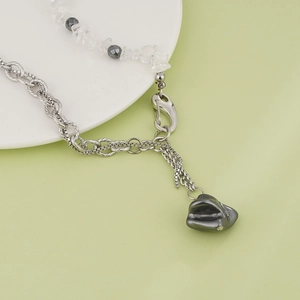 Dettaglio ravvicinato della collana a catena mista con pietre irregolari e ciondolo grigio