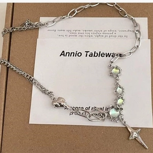 Detail view of a mixed-chain silver necklace with opal stones and heart pendant