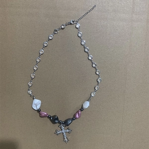 Detail view of heart pearl necklace with sparkling rhinestone chain and cross pendant