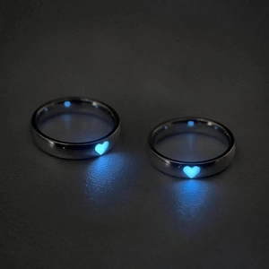 Dettaglio macro di anelli per coppia regolabili con cuore blu luminoso al buio