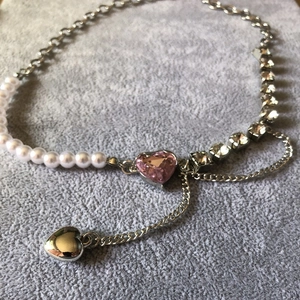 Detail of multi-strand necklace with pink heart stone, pearls and crystal chain