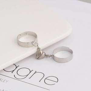 Adjustable magnetic heart rings for couples in polished silver finish on a white tray