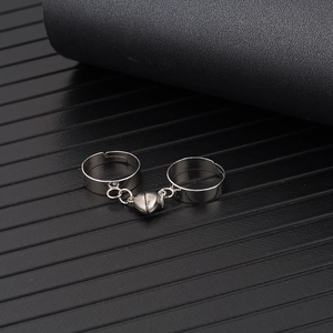 Close-up of magnetic heart connector on silver adjustable open couple rings