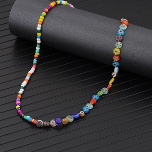 Collier bohème fait main avec perles de fleurs en verre colorées sur fond noir