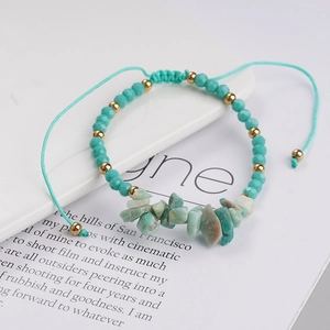 Detail of handmade woven bracelet with turquoise beads and natural raw stone accents