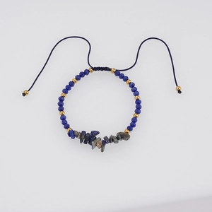 Detail of handmade woven adjustable blue bead bracelet with natural gemstone fragments