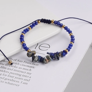 Detail of bohemian woven bracelet with blue beads, gold spacers and natural stone chips