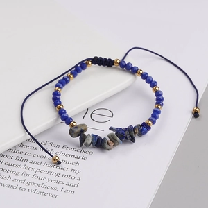 Macro detail of bohemian lapis lazuli woven bracelet with gold beads and stone texture