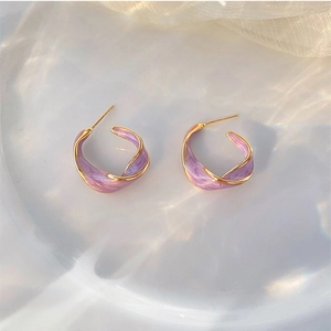 Vue détaillée des boucles d'oreilles créoles torsadées dorées avec émail marbré violet