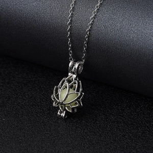 Vue détaillée du pendentif lotus argenté avec perle lumineuse sur fond en cuir noir