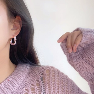Boucles d'oreilles créoles torsadées violettes de style français portées par un mannequin