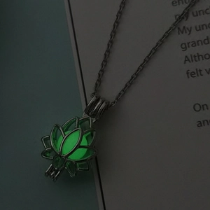 Perle verte luminescente dans un pendentif lotus évidé sur chaîne fine